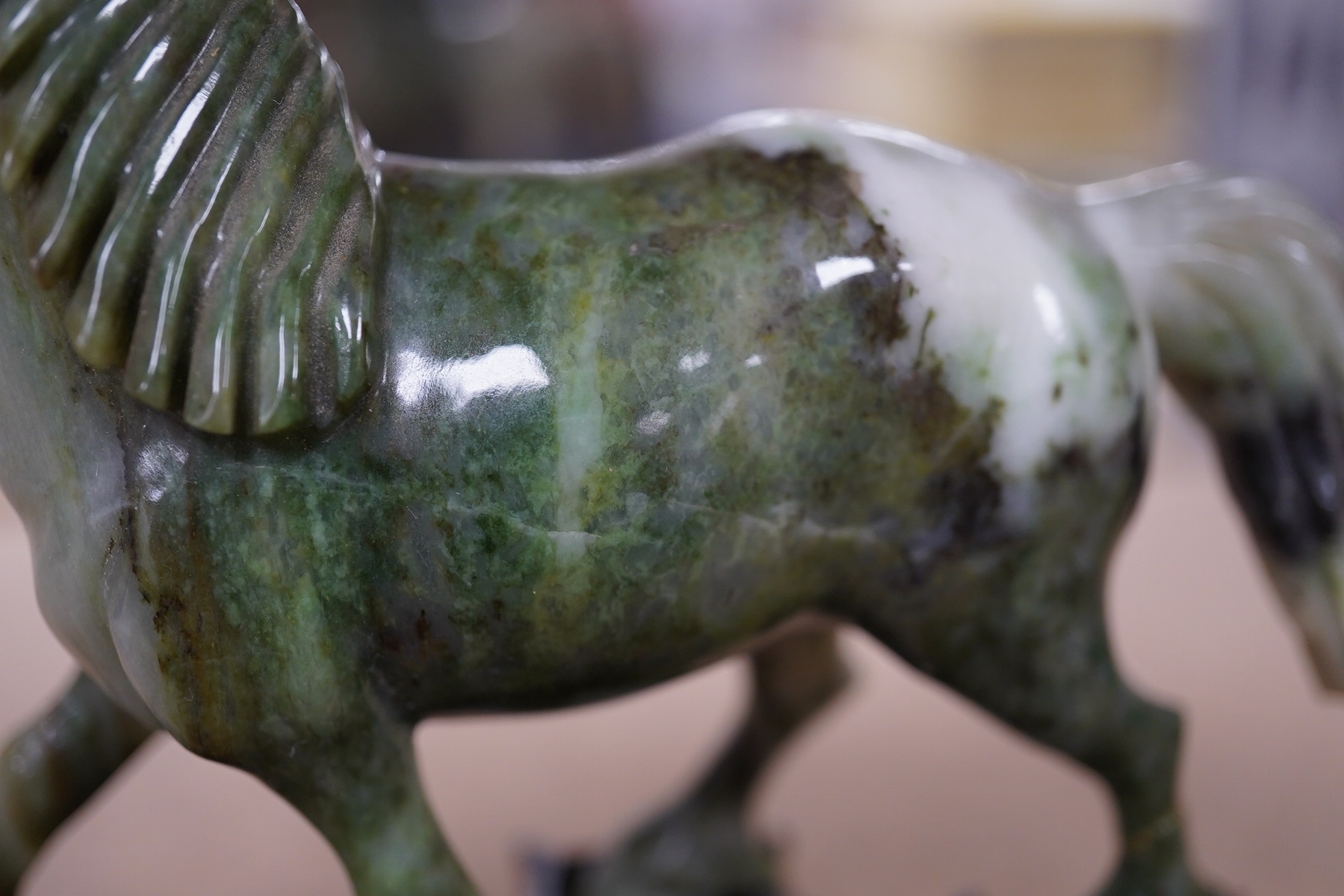 A pair of mid 20th century Chinese jadeite figures of horses, raised on hardwood stands, 13cm wide. Condition - fair, two legs broken and re-glued